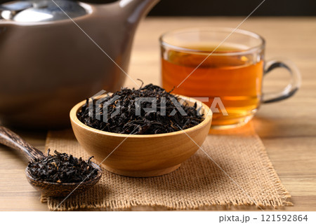 Dried black tea leaves and hot tea drink in cup glass 121592864