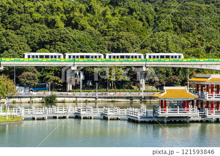 A train traveling on the Wenhu or Brown Line of the Taipei MRT, Taiwan, passes by Taipei Dahu Park. 121593846