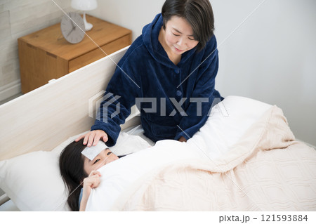 子供の風邪を看病する母親のイメージ 121593884