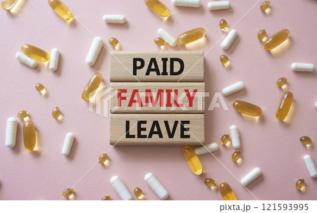 Paid Family Leave symbol. Concept words Paid Family Leave on wooden blocks. Beautiful pink background with pills. Healthcare and Paid Family Leave concept. Copy space. 121593995