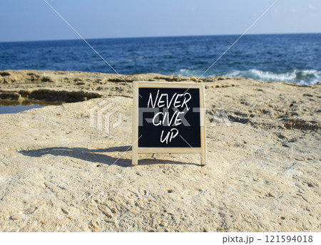 Never give up symbol. Blackboard with Concept words Never give up. Beautiful sea background. Business and Never give up concept. Copy space. 121594018