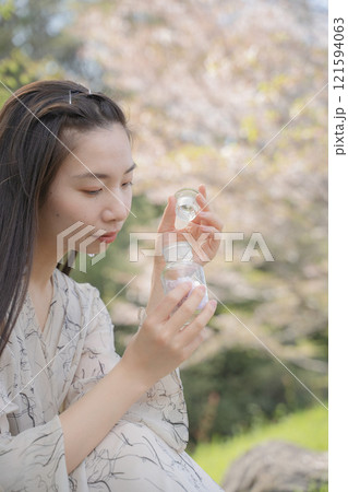 桜の入った瓶を見つめる女性 桜の入った瓶を見つめる女性 121594063