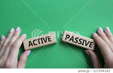 Active or Passive symbol. Concept word Active or Passive on wooden blocks. Businessman hand. Beautiful green background. Business and Active or Passive concept. Copy space Active or Passive symbol. Concept word Active or Passive on wooden blocks. Businessman hand. Beautiful green background. Business and Active or Passive concept. Copy space 121594182