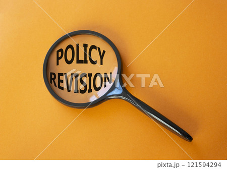 Policy revision symbol. Concept word Policy revision on magnifying glass. Beautiful orange background. Business and Policy revision concept. Copy space Policy revision symbol. Concept word Policy revision on magnifying glass. Beautiful orange background. Business and Policy revision concept. Copy space 121594294