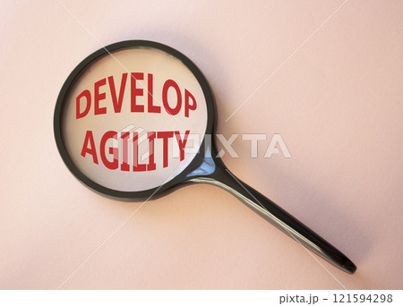 Develop agility symbol. Concept word Develop agility on magnifying glass. Beautiful pink background. Business and Develop agility concept. Copy space 121594298