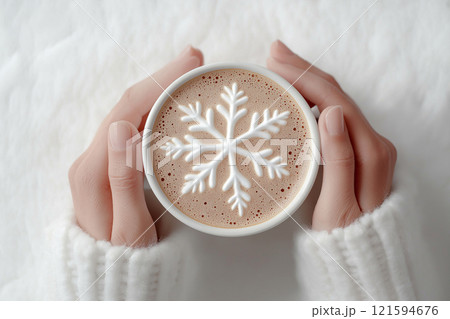 Hands in white sweater cuffs holding a cup of coffee or cocoa with a snowflake latte art on its foam, evoking winter themes, comfort, and coziness during cold seasons. Coffee lovers concept Hands in white sweater cuffs holding a cup of coffee or cocoa with a snowflake latte art on its foam, evoking winter themes, comfort, and coziness during cold seasons. Coffee lovers concept 121594676