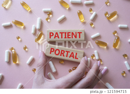 Patient Portal symbol. Concept word Patient Portal on wooden blocks. Beautiful pink background with pills. Doctor Hand. Medicine and Patient Portal concept. Copy space 121594715