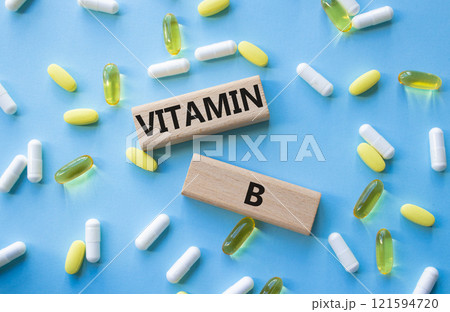 Vitamin B symbol. Concept word Vitamin B on wooden blocks. Beautiful blue background with pills. Medicine and Vitamin B concept. Copy space Vitamin B symbol. Concept word Vitamin B on wooden blocks. Beautiful blue background with pills. Medicine and Vitamin B concept. Copy space 121594720