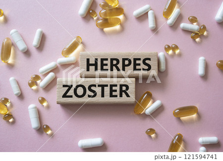 Herpes Zoster symbol. Concept word Herpes Zoster on wooden blocks. Beautiful pink background with pills. Medicine and Herpes Zoster concept. Copy space 121594741