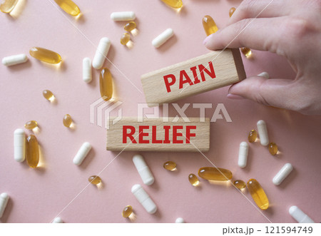 Pain Relief symbol. Concept word Pain Relief on wooden blocks. Beautiful pink background with pills. Doctor Hand. Medicine and Pain Relief concept. Copy space Pain Relief symbol. Concept word Pain Relief on wooden blocks. Beautiful pink background with pills. Doctor Hand. Medicine and Pain Relief concept. Copy space 121594749