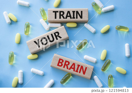 Train Your Brain symbol. Concept words Train Your Brain on wooden blocks. Beautiful blue background with pills. Healthcare and Train Your Brain concept. Copy space. Train Your Brain symbol. Concept words Train Your Brain on wooden blocks. Beautiful blue background with pills. Healthcare and Train Your Brain concept. Copy space. 121594813