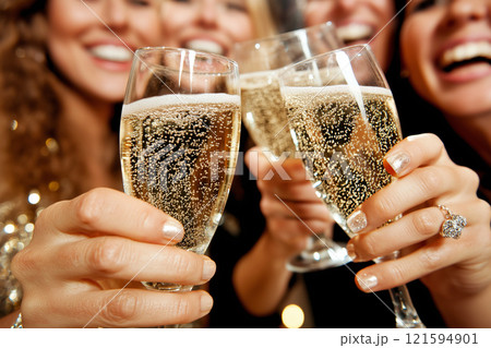 A cheerful celebration featuring close friends clinking champagne glasses in joy and happiness. Social gathering, representing a festive and fun occasion, filled with laughter and sparkling moments. 121594901
