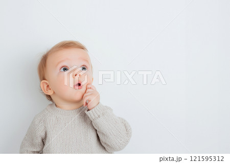 A shocked cute baby with wide eyes and an open mouth looking at the camera, surprise, wow concept. Amazed, excited child, funny reaction on amazing news, loud sound or something new A shocked cute baby with wide eyes and an open mouth looking at the camera, surprise, wow concept. Amazed, excited child, funny reaction on amazing news, loud sound or something new 121595312