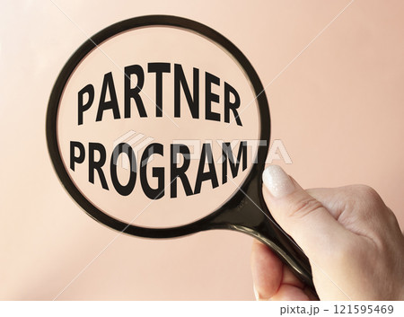 Partner Program symbol. Concept words Partner Program on magnifying glass. Businessman hand. Beautiful pink background. Business and Partner Program concept. Copy space. Partner Program symbol. Concept words Partner Program on magnifying glass. Businessman hand. Beautiful pink background. Business and Partner Program concept. Copy space. 121595469