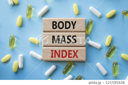 Body Mass Index symbol. Concept word Body Mass Index on wooden blocks. Beautiful blue background with pills. Medicine and Body Mass Index concept. Copy space Body Mass Index symbol. Concept word Body Mass Index on wooden blocks. Beautiful blue background with pills. Medicine and Body Mass Index concept. Copy space 121595836