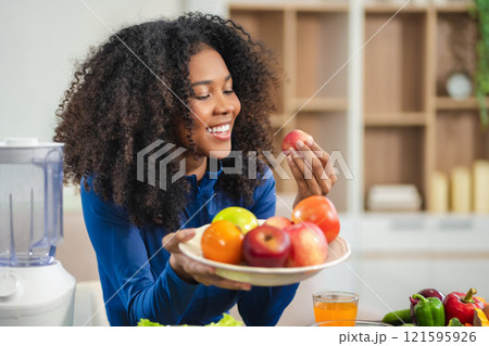 Fit happy black woman enjoys healthy fruit breakfast after yoga training. fitness, nutrition, home lifestyle. 121595926