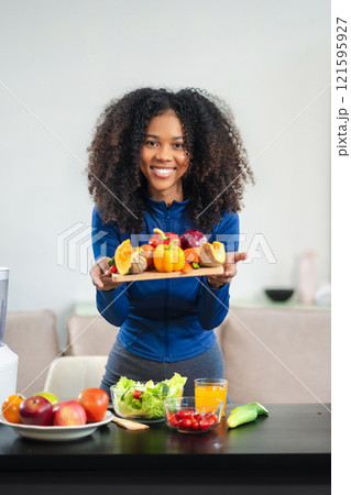 Fit happy black woman enjoys healthy fruit breakfast after yoga training. fitness, nutrition, home lifestyle. Fit happy black woman enjoys healthy fruit breakfast after yoga training. fitness, nutrition, home lifestyle. 121595927