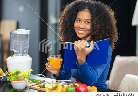Fit happy black woman enjoys healthy fruit breakfast after yoga training. fitness, nutrition, home lifestyle. 121595935