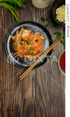 Traditional kimchi dish on rustic wooden background. Korean cuisine and traditional side dish concept Traditional kimchi dish on rustic wooden background. Korean cuisine and traditional side dish concept 121595971
