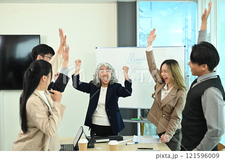 Group of business professionals celebrating their successful project in the office 121596009