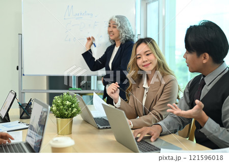 Professional marketing team discussing strategies during meeting in the modern office 121596018
