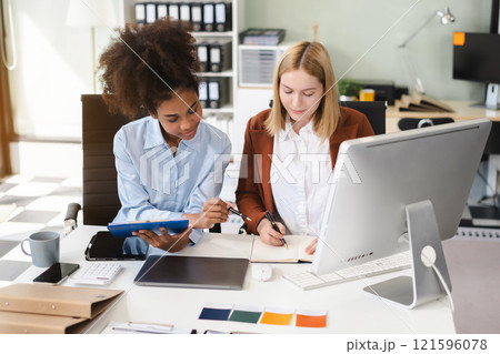 Diverse professionals collaborate on project analysis with financial graphs. Strategic teamwork and insights drive company growth and success. 121596078