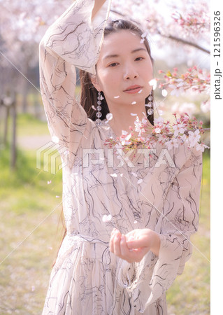 桜の木の下で両手を広げる若い女性 桜の木の下で両手を広げる若い女性 121596326