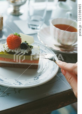 イチゴのケーキと紅茶のティータイムと女性の手元 イチゴのケーキと紅茶のティータイムと女性の手元 121596465