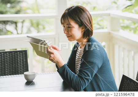 テラスでタブレット端末を使う女性 121596478