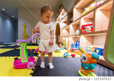 Young child enjoying playroom with colorful toys and activities. Concept of joyful play and early education 121597013