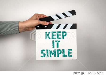 Keep it simple. Hand holding movie clapper 121597243