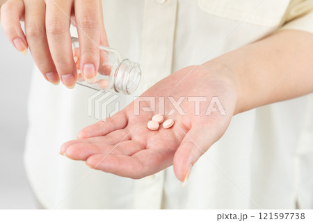 薬を瓶から出す女性02 121597738