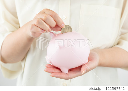 貯金箱にお金を入れる女性の手元01 貯金箱にお金を入れる女性の手元01 121597742