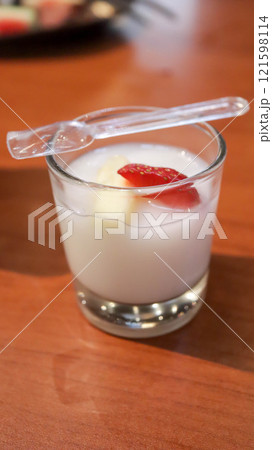 Vanilla jelly pudding with banana and strawberry fruit slice dessert appetizer in a small glass cup. Vanilla jelly pudding with banana and strawberry fruit slice dessert appetizer in a small glass cup. 121598114