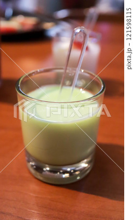 Matcha tea green jelly pudding dessert in a small glass. 121598115