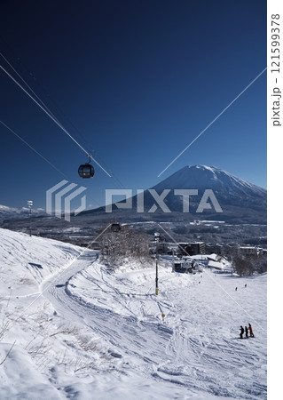 ニセコ東急 グラン・ヒラフ・ゲレンデのせんの木コースからエースゴンドラと羊蹄山を望む 121599378