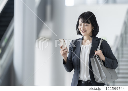 スマートフォンの画面を見るアラフィフのビジネスウーマン 121599744