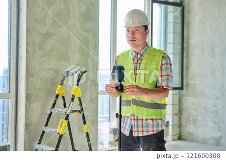 Portrait of male industrial worker in vest helmet with professional equipment Portrait of male industrial worker in vest helmet with professional equipment 121600308