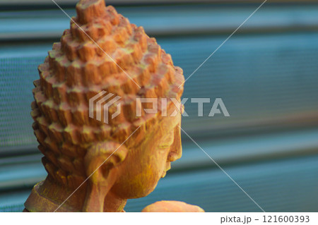 Close-up of a brown head statue buddhist character. Side photo on dark background with lines with perspective, maybe Buddha Close-up of a brown head statue buddhist character. Side photo on dark background with lines with perspective, maybe Buddha 121600393
