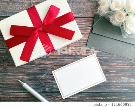 木製テーブルの上のプレゼントとメッセージカード 121600953