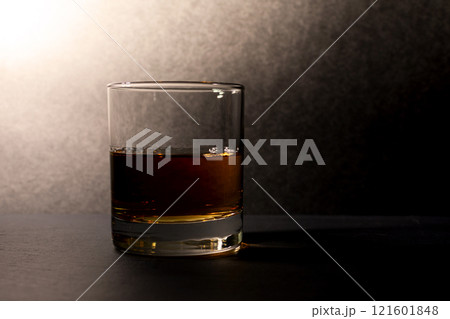 glass goblet with whiskey on a dark background 121601848