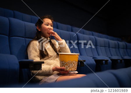 ポップコーンを食べながら映画を観る女の子 ポップコーンを食べながら映画を観る女の子 121601989