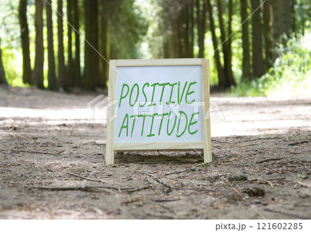 Positive attitude symbol. Concept word Positive attitude on white chalk background. Beautiful forest background. Business and Positive attitude concept. Copy space 121602285