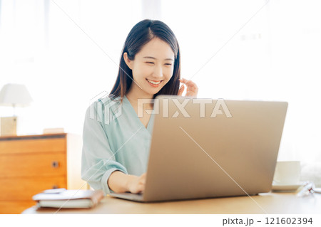リビングでパソコンを使う女性 121602394