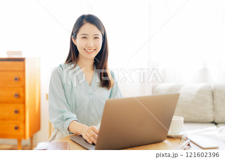 リビングでパソコンを使う女性 121602396