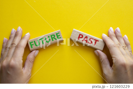 Future or Past symbol. Concept word Future or Past on wooden blocks. Businessman hand. Beautiful yellow background. Business and Future or Past concept. Copy space 121603229