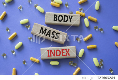 Body Mass Index symbol. Concept word Body Mass Index on wooden blocks. Beautiful purple background with pills. Medicine and Body Mass Index concept. Copy space Body Mass Index symbol. Concept word Body Mass Index on wooden blocks. Beautiful purple background with pills. Medicine and Body Mass Index concept. Copy space 121603284