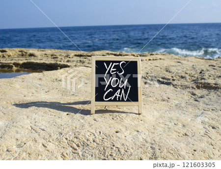 Yes You Can symbol. Concept words Yes You Can on black chalk blackboard blocks. Beautiful sea green background. Business and Yes You Can concept. Copy space. Yes You Can symbol. Concept words Yes You Can on black chalk blackboard blocks. Beautiful sea green background. Business and Yes You Can concept. Copy space. 121603305