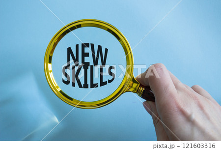 New skills symbol. Magnifying Glass with Concept word New skills. Businessman hand. Beautiful blue background. Business and New skills concept. Copy space 121603316
