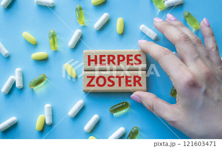 Herpes Zoster symbol. Concept word Herpes Zoster on wooden blocks. Beautiful blue background with pills. Doctor Hand. Medicine and Herpes Zoster concept. Copy space 121603471